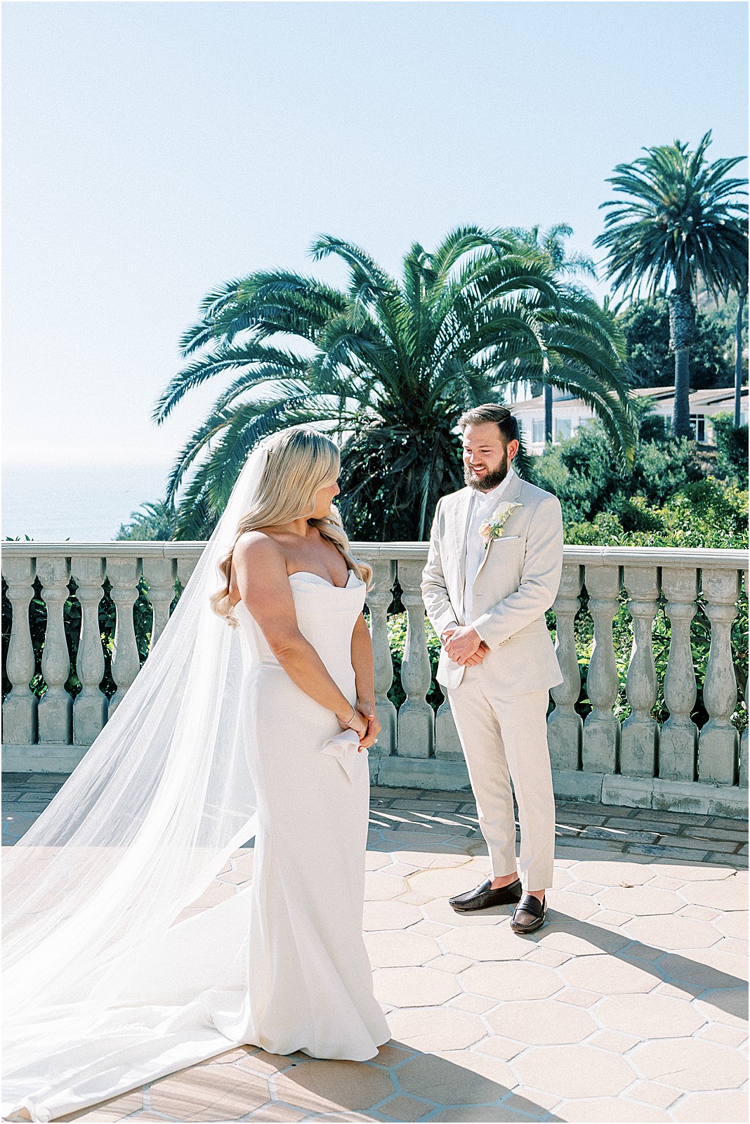 bride showing off her gown to the groom during the first look at bel air bay club in pacific palisades