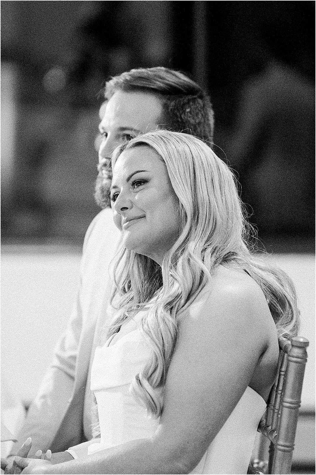 couple sitting at their sweetheart table listening to speeches