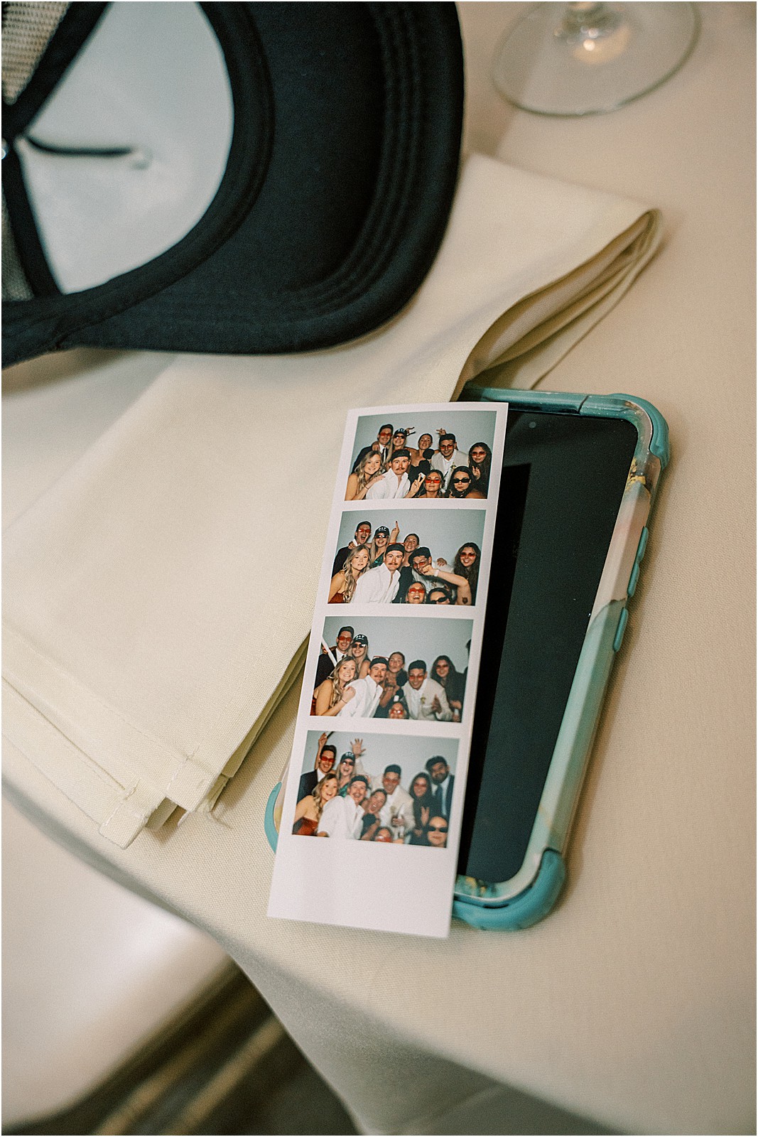 a photo strip sitting on a guests phone during the reception