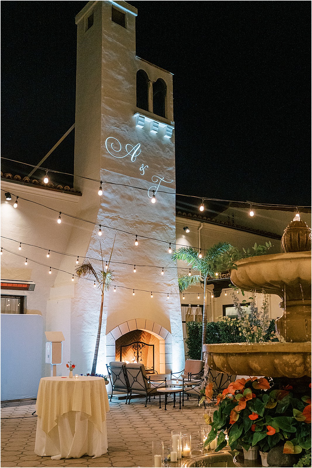 a lit monogram of the couples initials projected on the chimney of bel air bay club