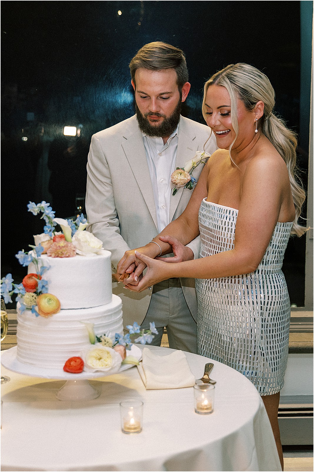 couple cutting their wedding cake with flowers at bel air bay club