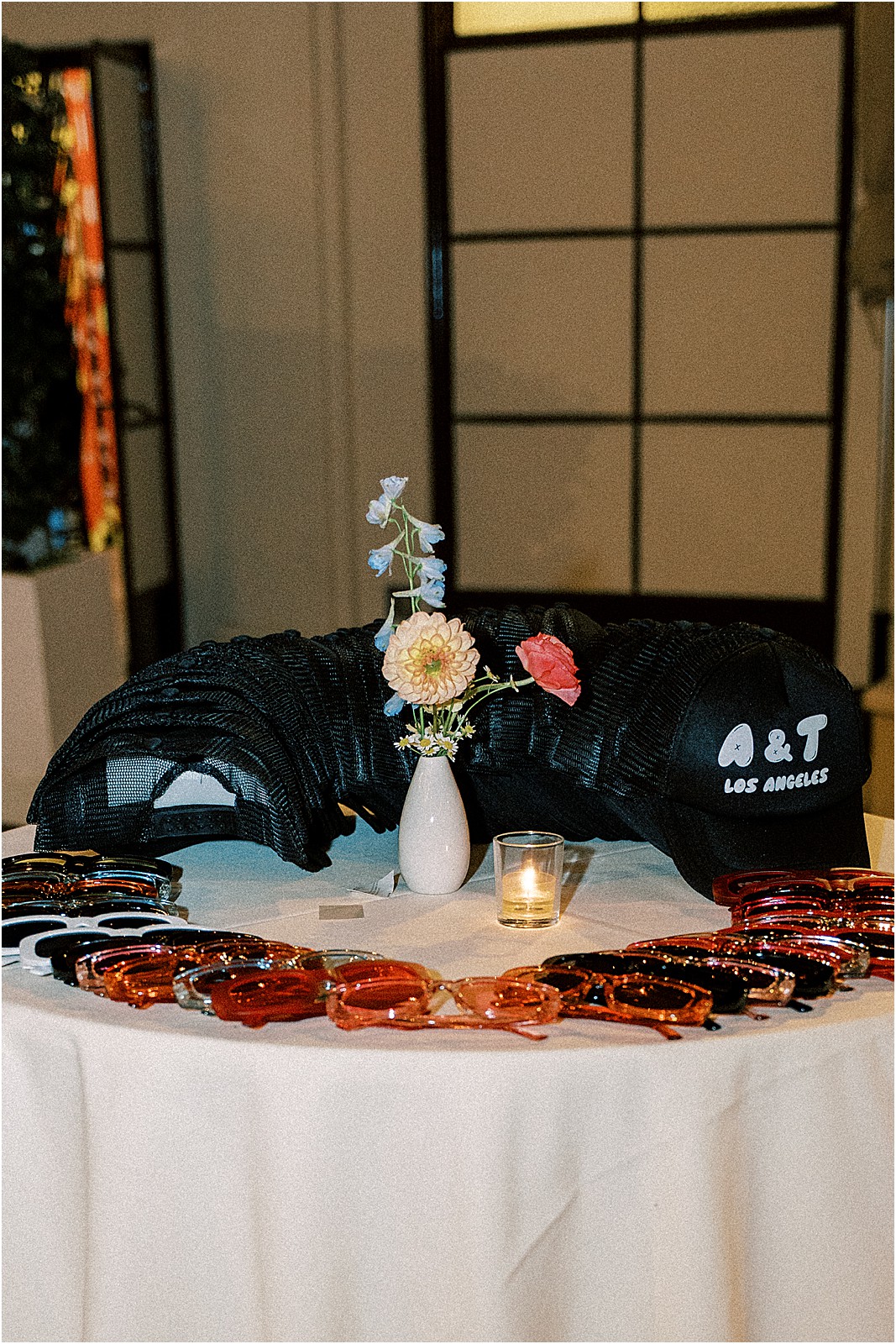 table shot of the couples merch, trucker hats and sunglasses during the reception