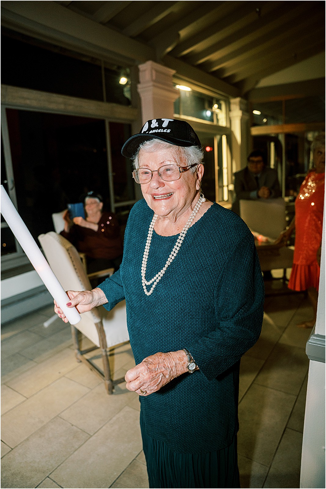 grandma with light up stick and a trucker hat with the couples initials during the reception at bel air bay club