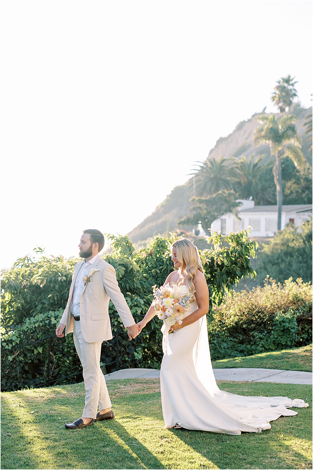 couple walking on bel air bay club lawn at sunset