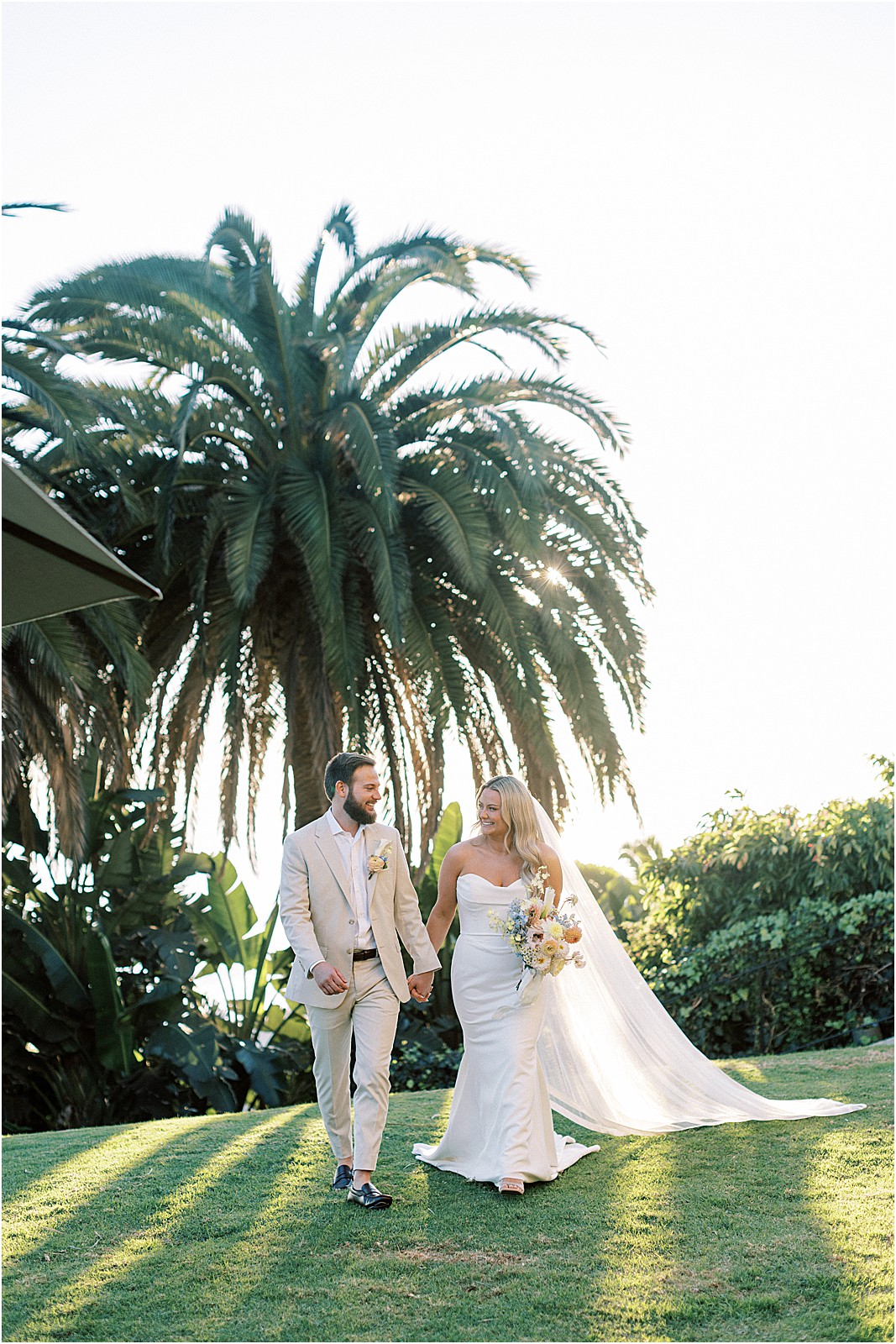 candid moment of the couple walking and laughing at sunset