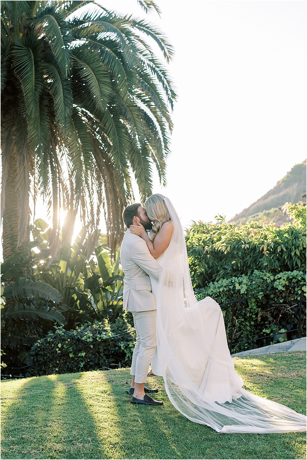 groom lifting bride on lawn at bel air bay club in pacific palisades