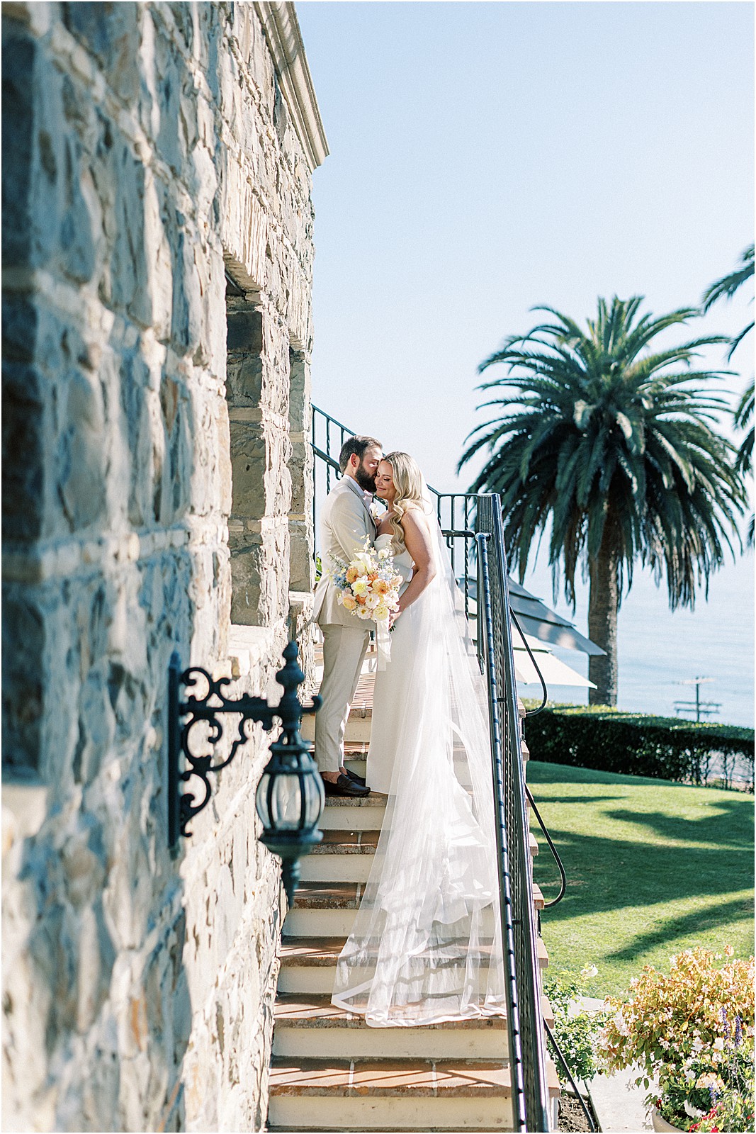 groom whispering to bride on the stairs before their wedding at bel air bay club